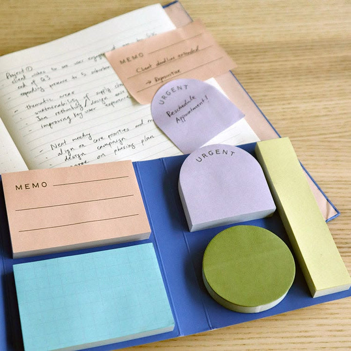 Colorful sticky notes with different shapes and sizes on a wooden surface