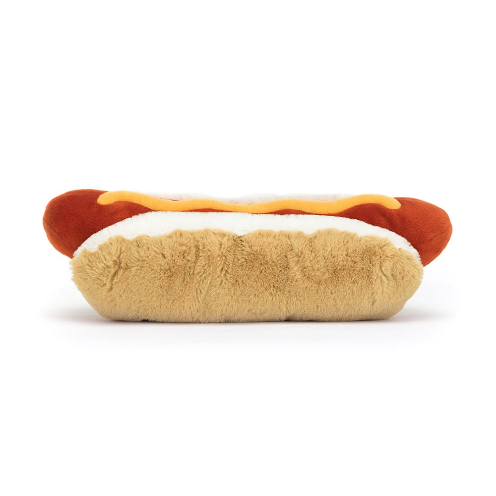 Plush toy shaped like a hot dog with mustard on a white background