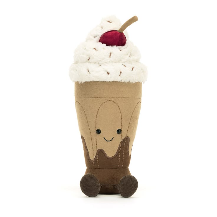 Plush toy resembling a ice cream cone with whipped cream and a cherry on top against a white background