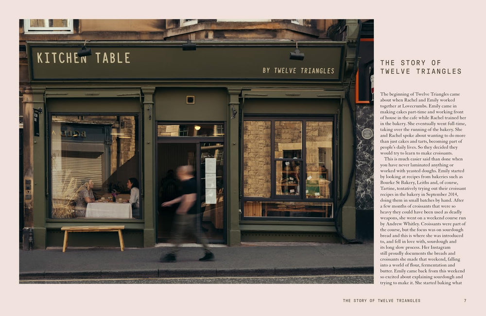  storefront with 'Kitchen Table' sign and people walking by