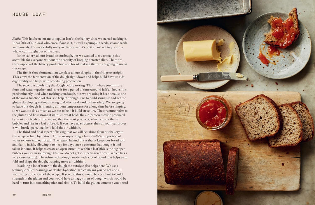 Bread loaf on a wooden cutting board with tomato spread, knife, and plates with bread slices.