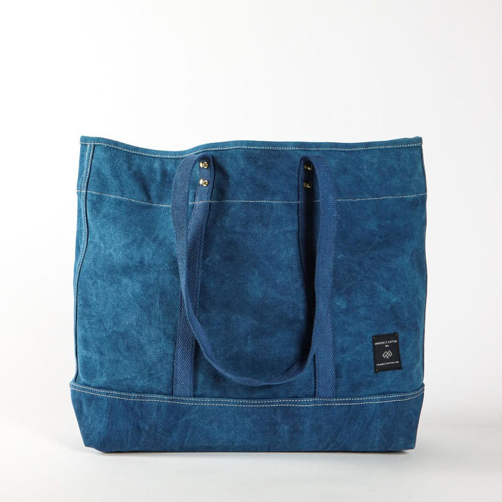 Blue tote bag with a visible brand label on a white background
