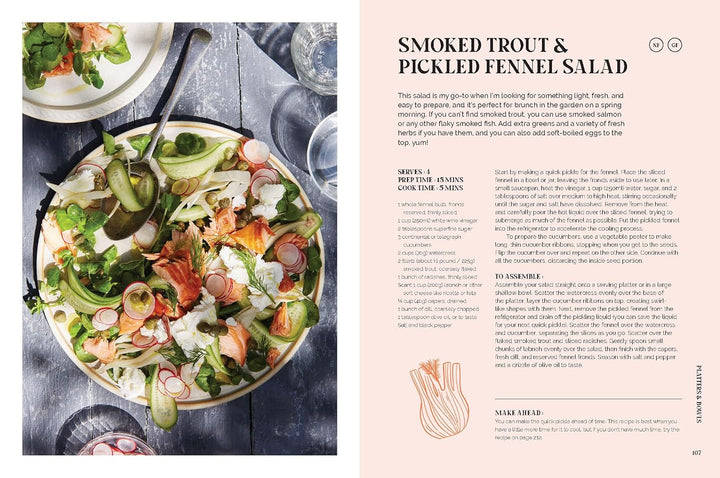 A two-page spread from a recipe book or magazine featuring a prepared salad on the left and the title 'SMOKED TROUT & PICKLED FENNEL SALAD' with recipe text on the right. The salad contains salmon, greens, radishes, and avocado on a dark rustic surface, while the right page has a pale peach background with descriptive text and small illustrations.
