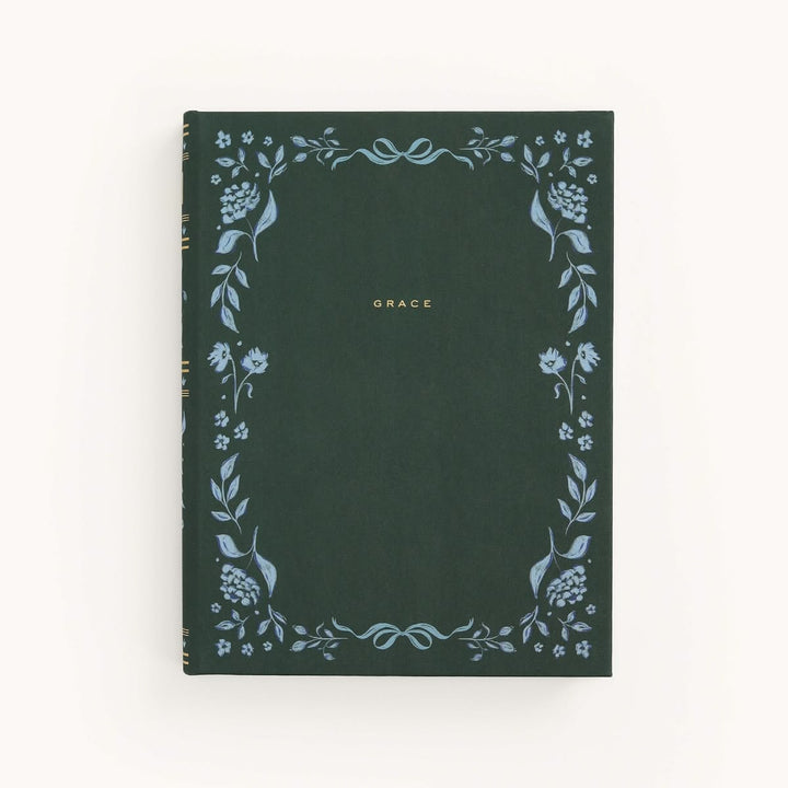 Dark green notebook with floral designs and 'GRACE' text on a white background