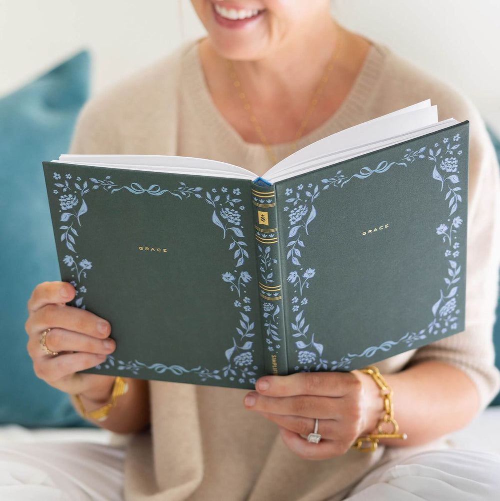Person holding a green notebook with floral patterns