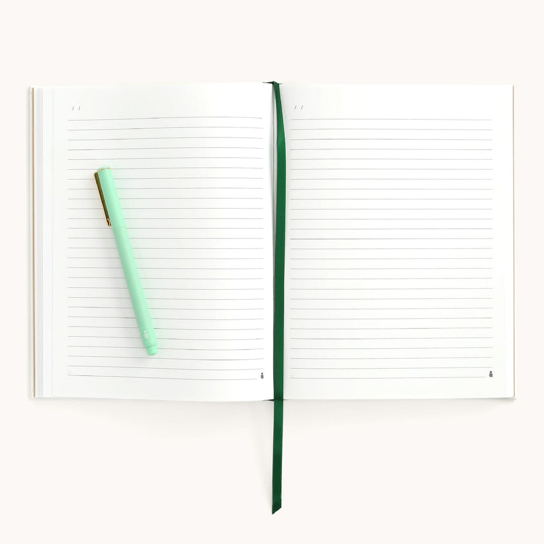 Open notebook with a green pen on a white background