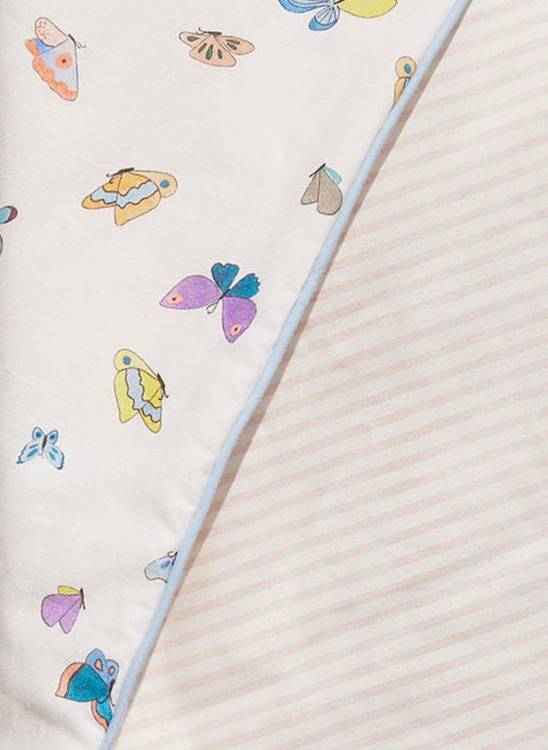 Colorful butterfly pattern on a fabric with a straw in the foreground.