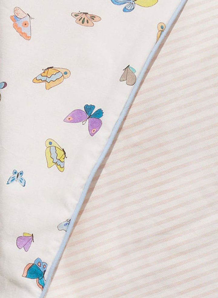 Colorful butterfly pattern on a fabric with a straw in the foreground.