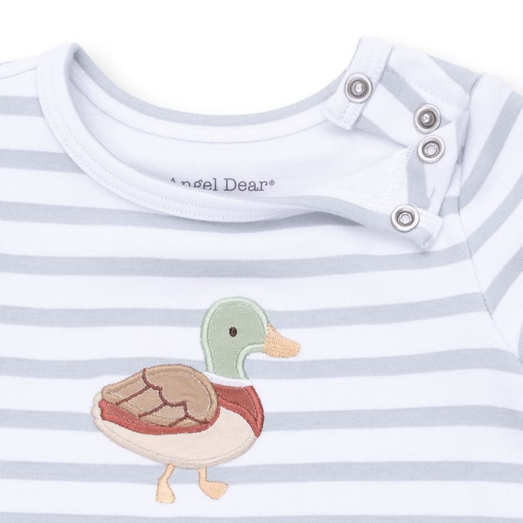 Close-up of a baby long-sleeve top with light gray and white horizontal stripes, featuring a colorful embroidered duck on the chest and three silver snap closures at the collar. The brand name 'Angel Dean' is visible inside the collar.