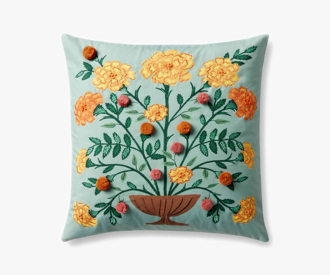 Decorative pillow with floral embroidery on a light blue background