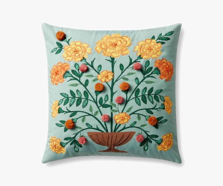 Decorative pillow with floral embroidery on a light blue background