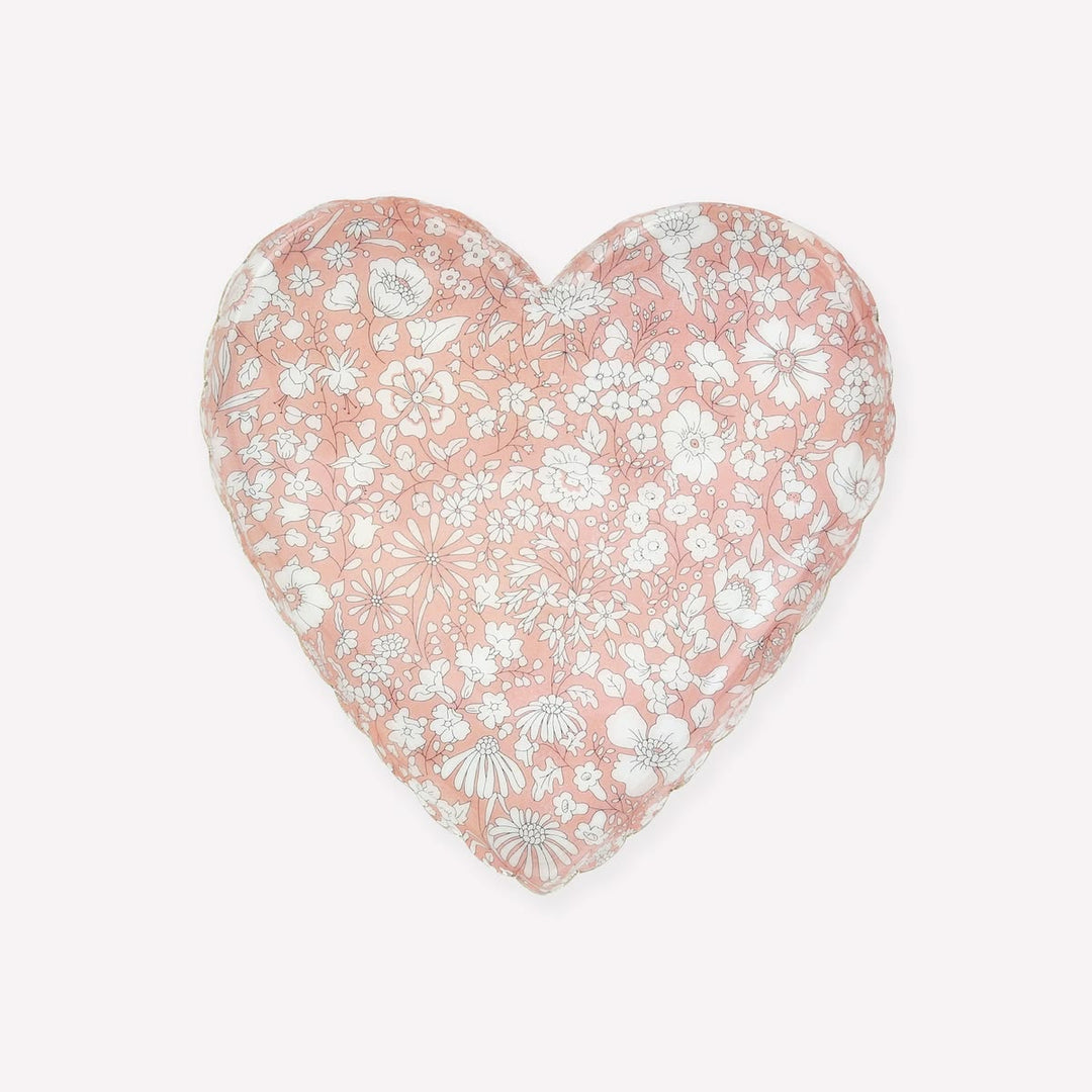 A heart-shaped decorative pillow featuring a delicate white and gray floral pattern on a soft pink background, shown against a plain off-white backdrop.