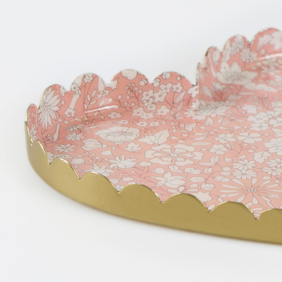 Decorative tray with pink floral pattern and gold rim on a white background