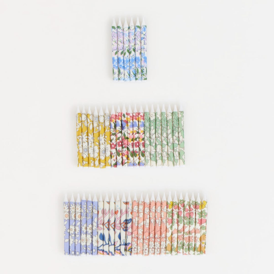 Set of colorful matchboxes with floral patterns on a white background