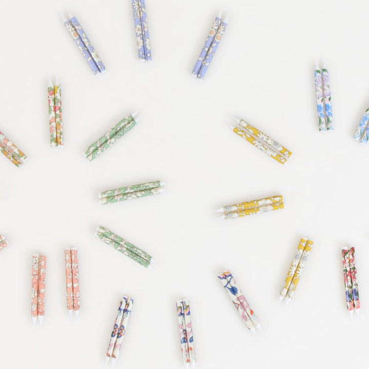 Colorful clothespins arranged in a scattered pattern on a white background