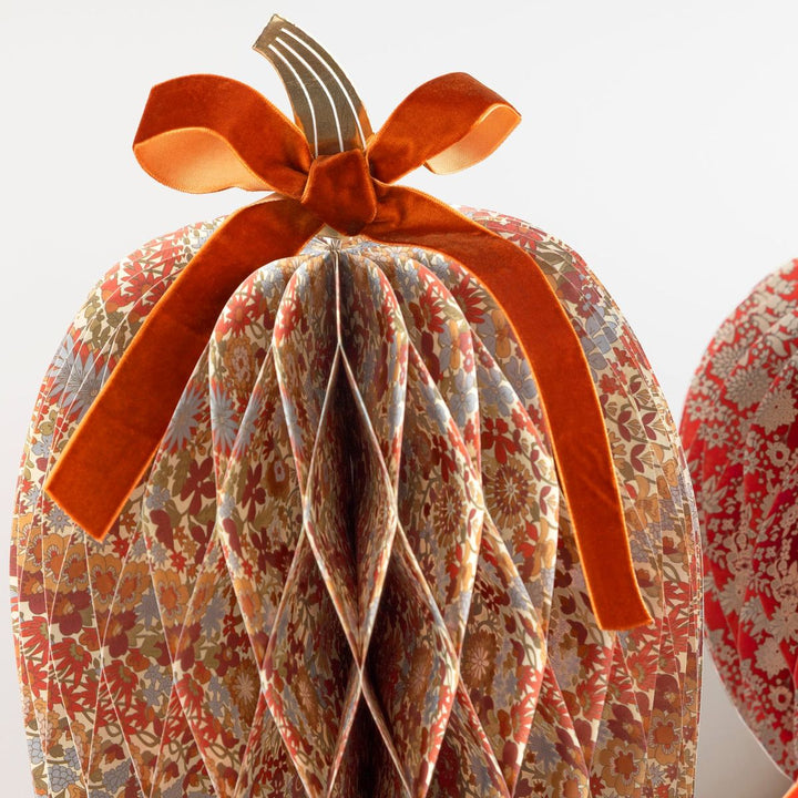 Decorative fabric pumpkin with a bow on a white background