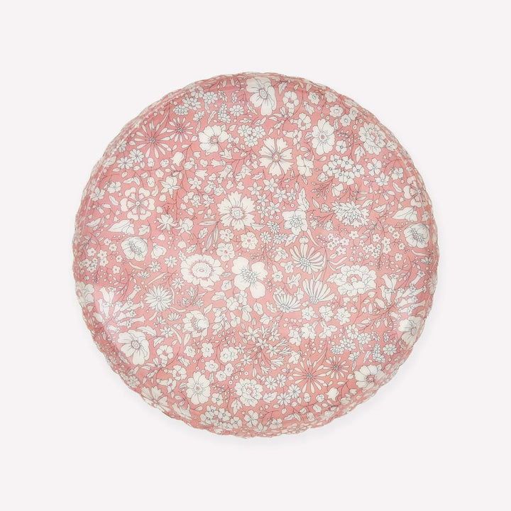 A round decorative tray or plate featuring a dense white and light gray floral pattern on a dusty pink background, shown from a top-down view against a light off-white backdrop.
