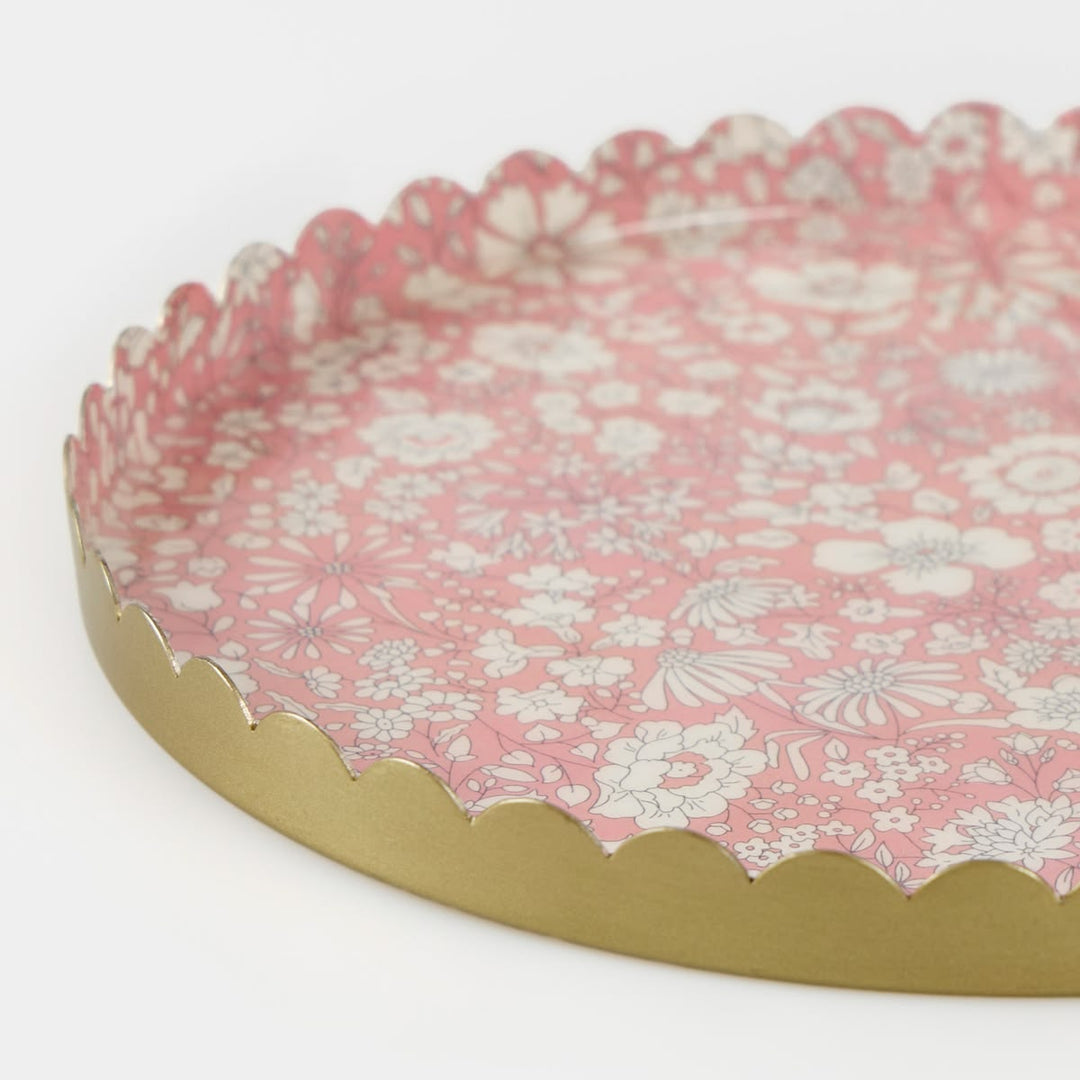 Round decorative tray with floral pattern and gold rim on a white background