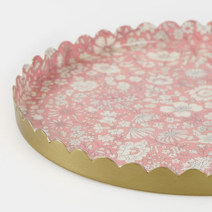 Round decorative tray with floral pattern and gold rim on a white background