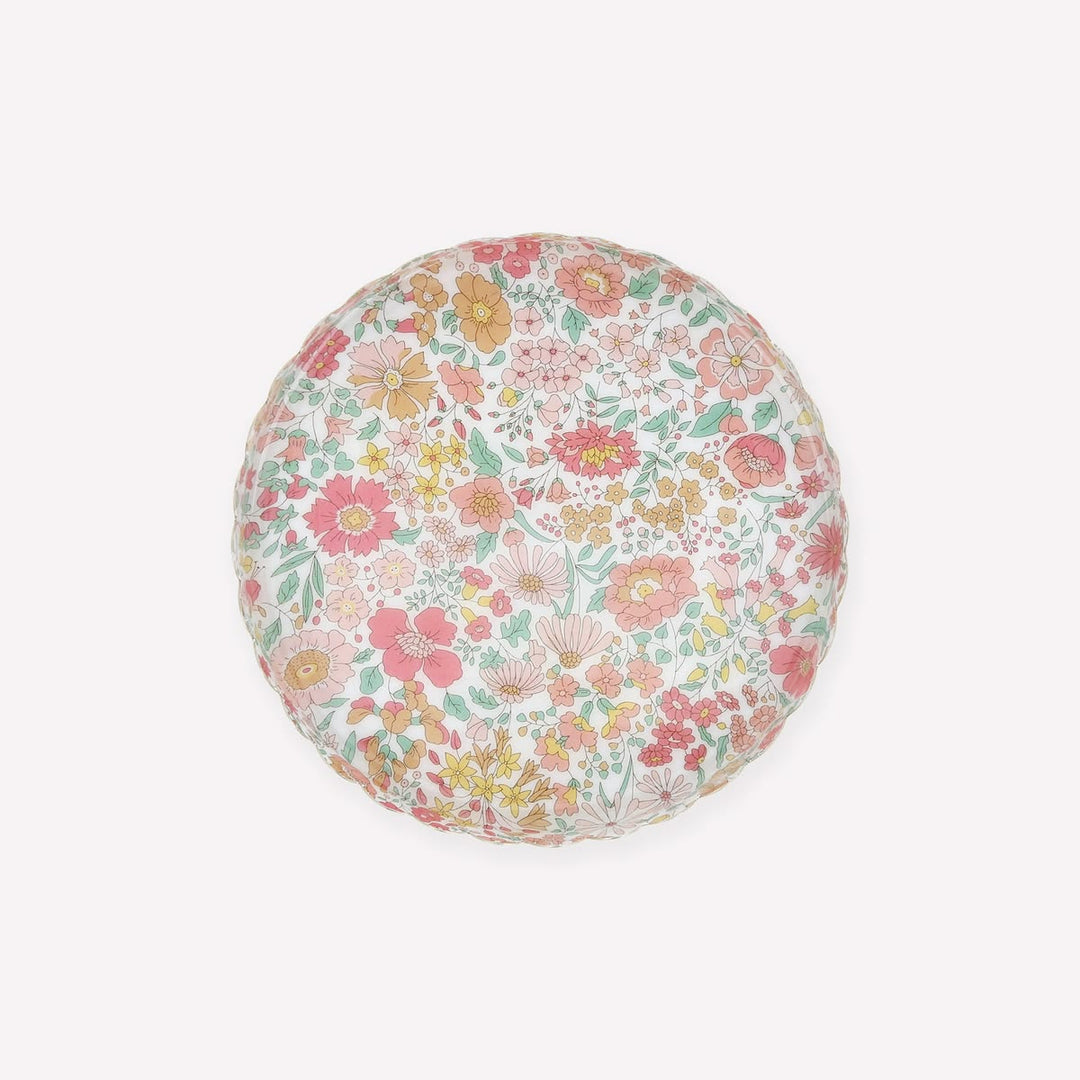 A round floor cushion with a dense, multicolor floral pattern on a white background, photographed from directly above on a light gray studio background.