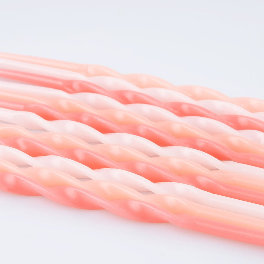 Twisted rope-style cords in a soft coral pink and pale peach color, shown in a close-up studio shot on a white background.