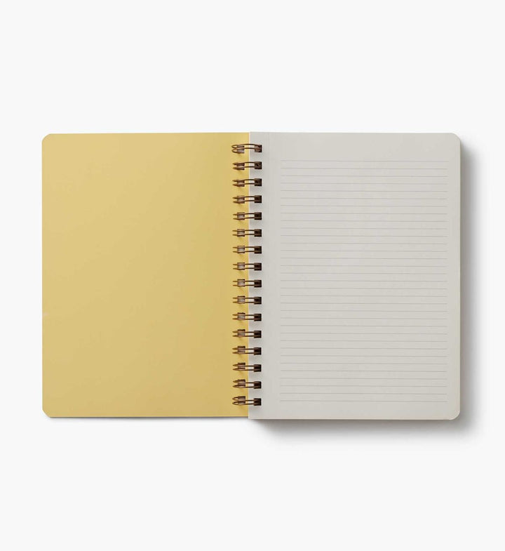 Open notebook with beige cover and white lined pages on a white background