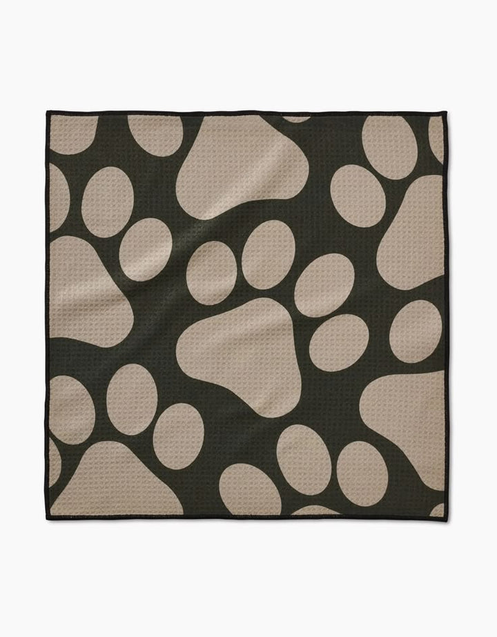 Black towel with beige paw print pattern on a white background