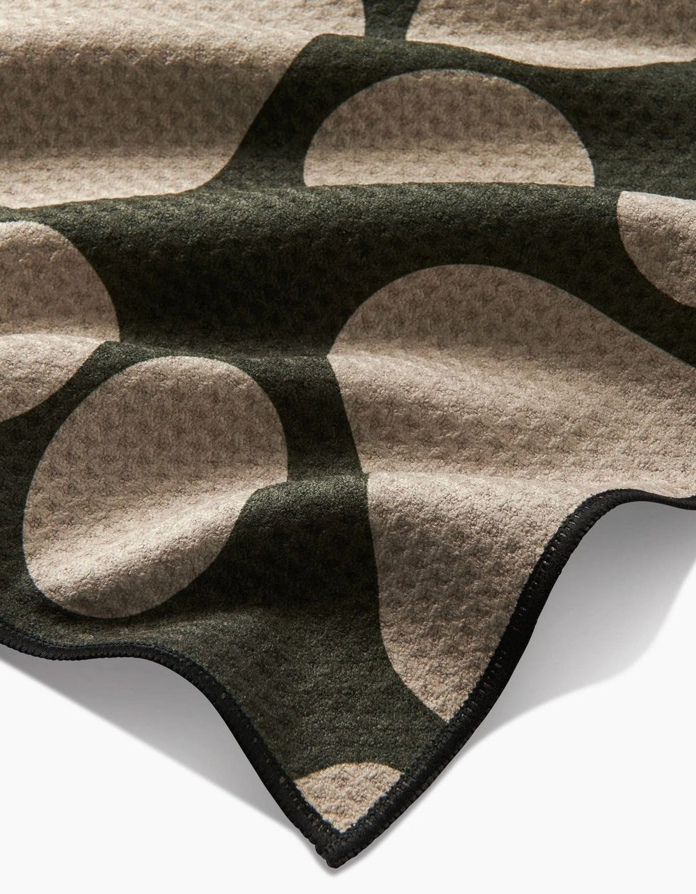 Close-up of a patterned rug with geometric shapes on a plain background