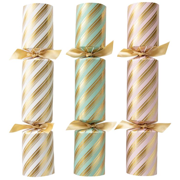 Three decorative crackers with striped patterns and gold ribbons on a white background