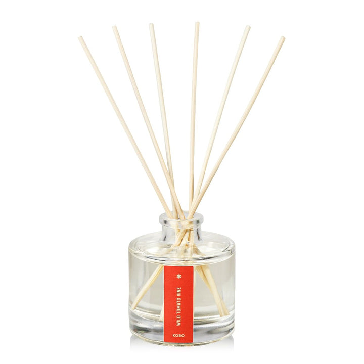 Clear glass diffuser bottle with wooden sticks on a white background