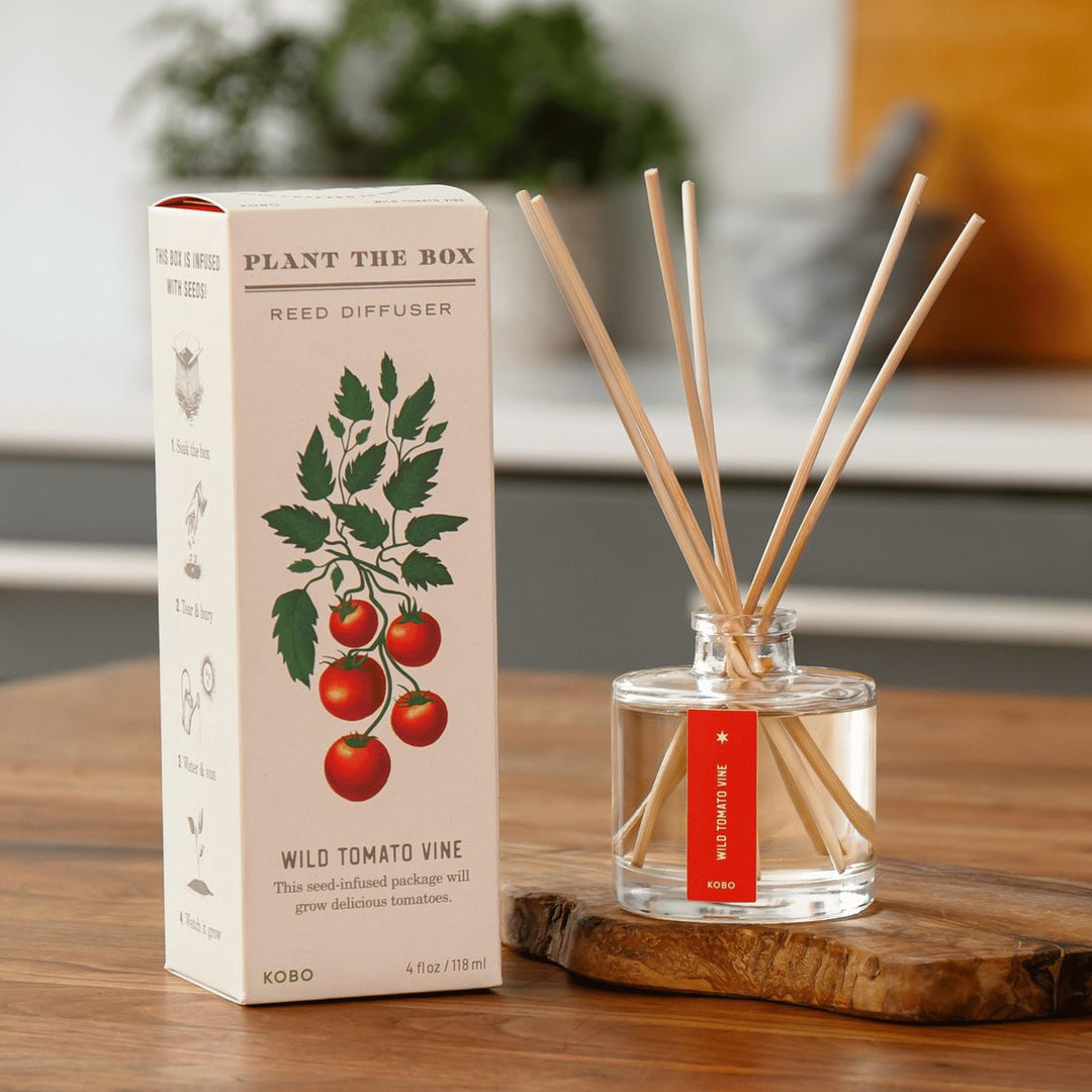 Reed diffuser with packaging on a wooden surface