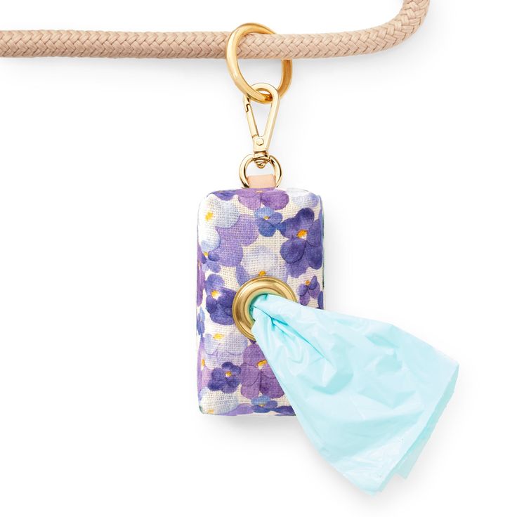 Decorative keychain with floral design and turquoise tassel on a white background