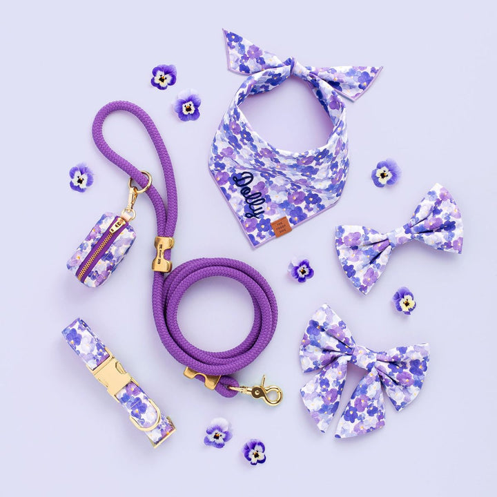 Purple pet accessories with floral patterns on a light purple background