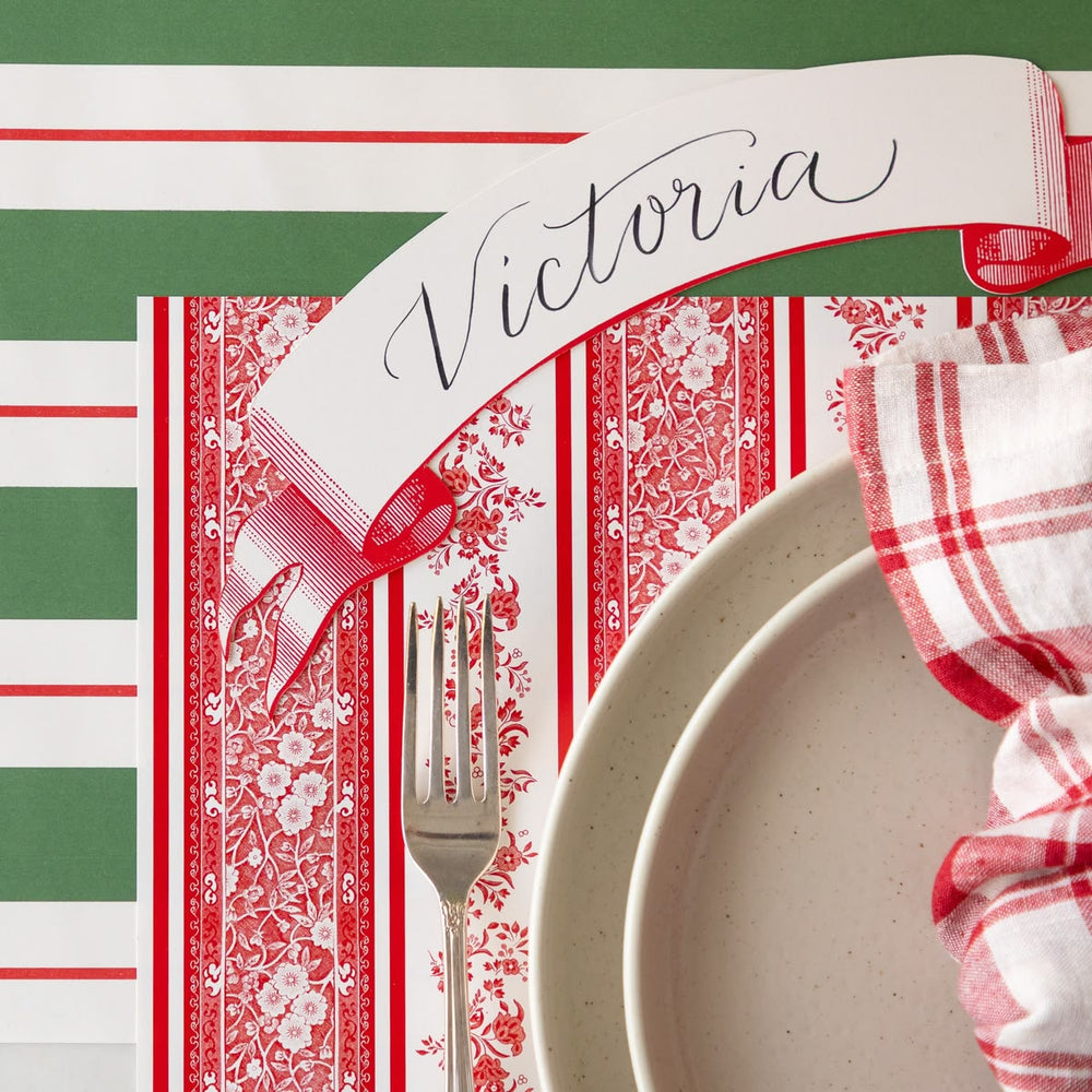 Placemat with 'Victoria' text, fork, and plate on a green background