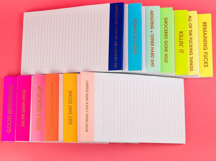 Set of colorful notepads with various text on a pink background