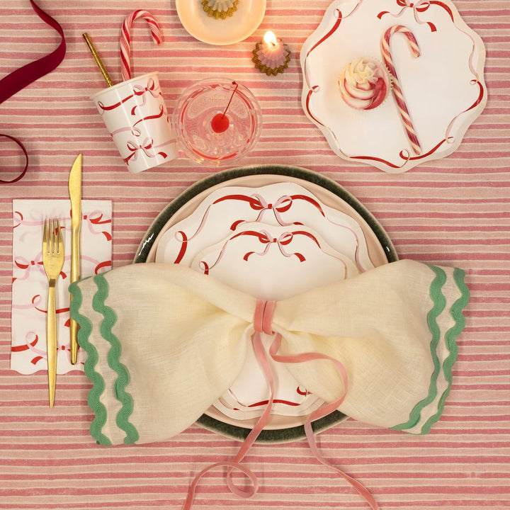 Decorative table setting with bow-shaped napkin on a striped tablecloth.