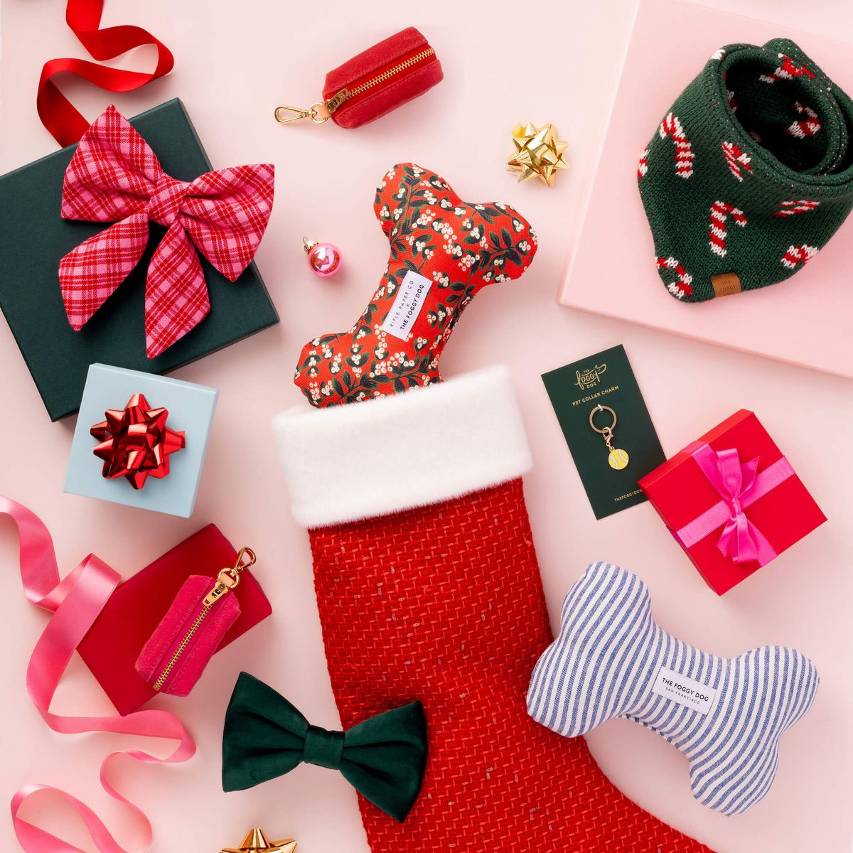 Christmas-themed items including a red stocking, gift boxes, ribbons, and decorative bows on a pink background.