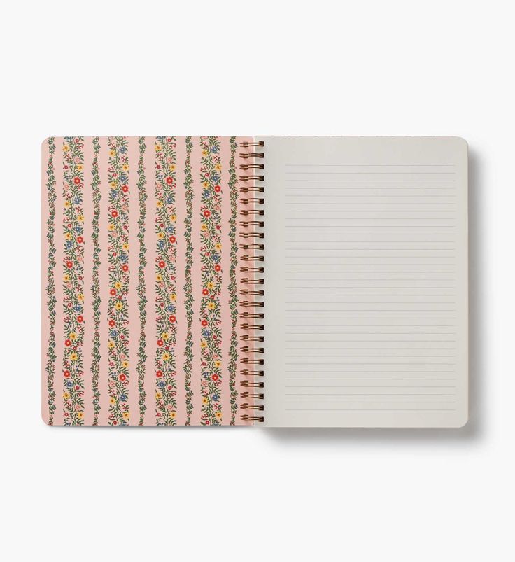 Notebook with floral patterned cover and white lined pages on a white background