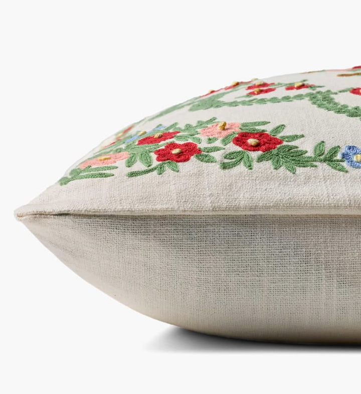 Decorative pillow with floral embroidery on a white background