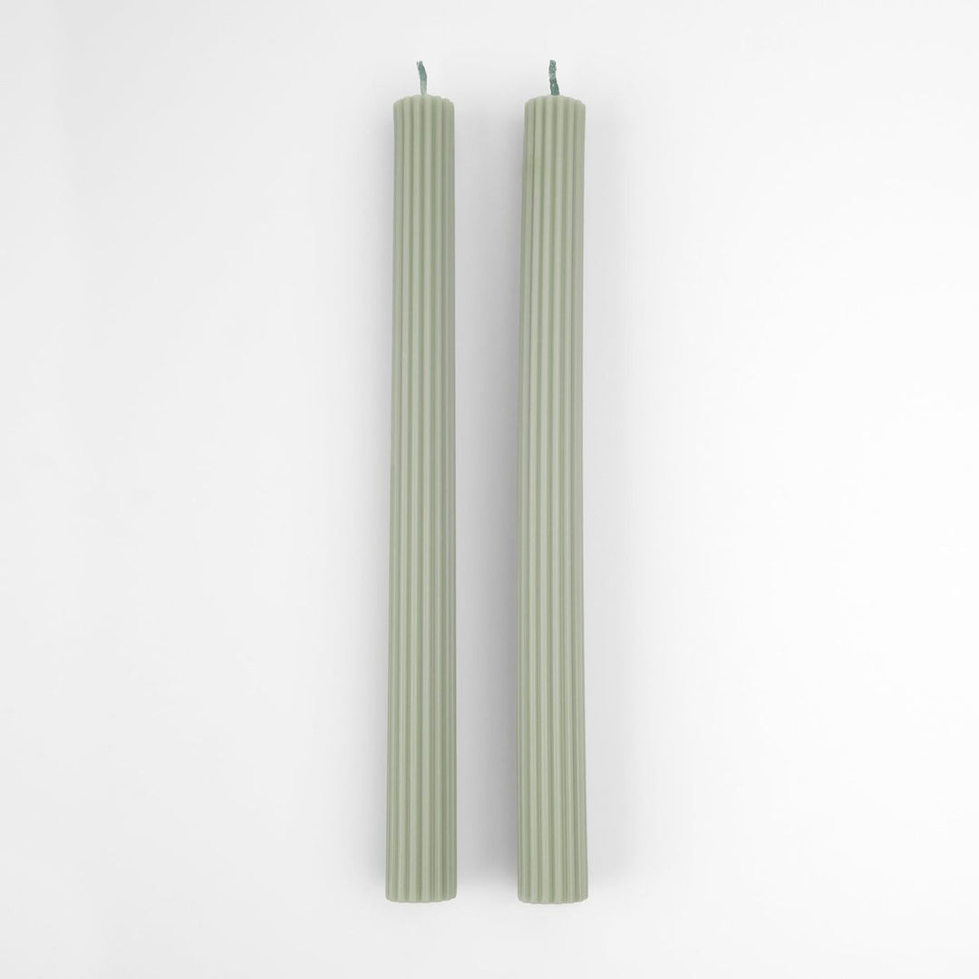 Two green candles on a white background