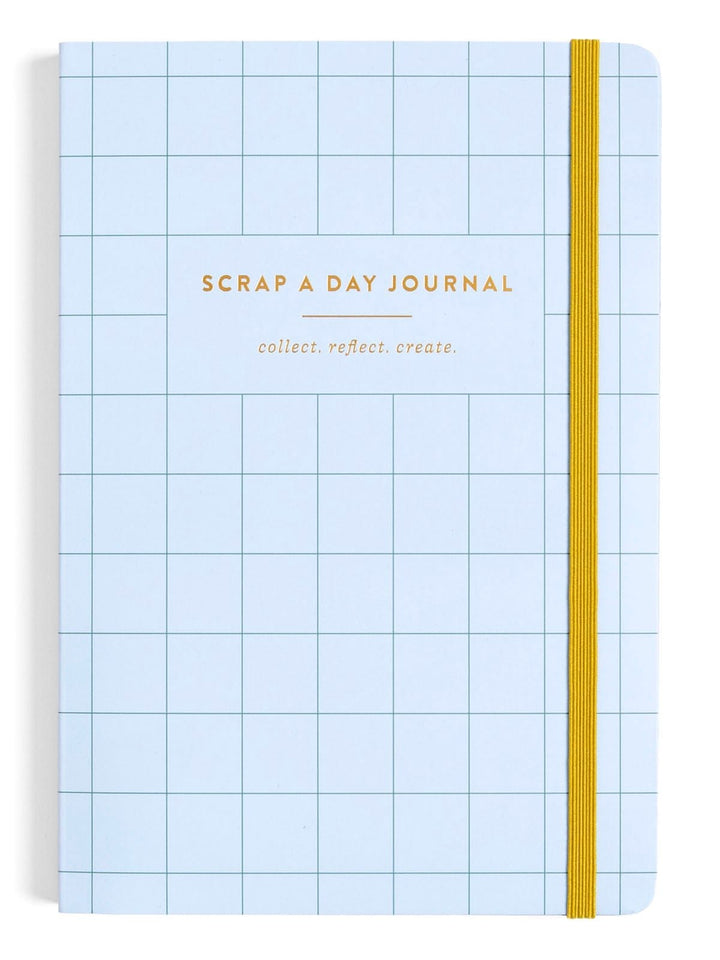 A light blue grid-patterned scrapbook journal with gold foil text reading 'SCRAP A DAY JOURNAL' and 'collect. reflect.
