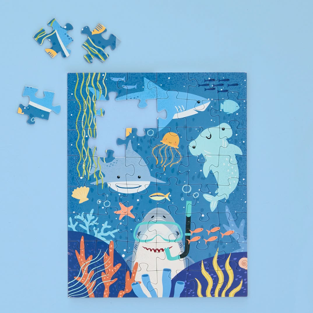Children's puzzle with shark and ocean theme on a blue background