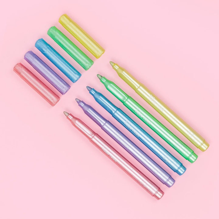 Set of colorful markers on a pink background