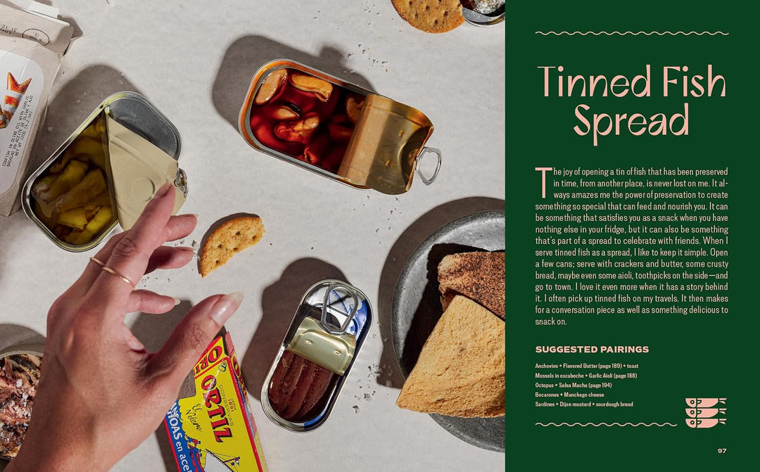 Tins of canned fish with crackers on a table, next to text about tinned fish spread.