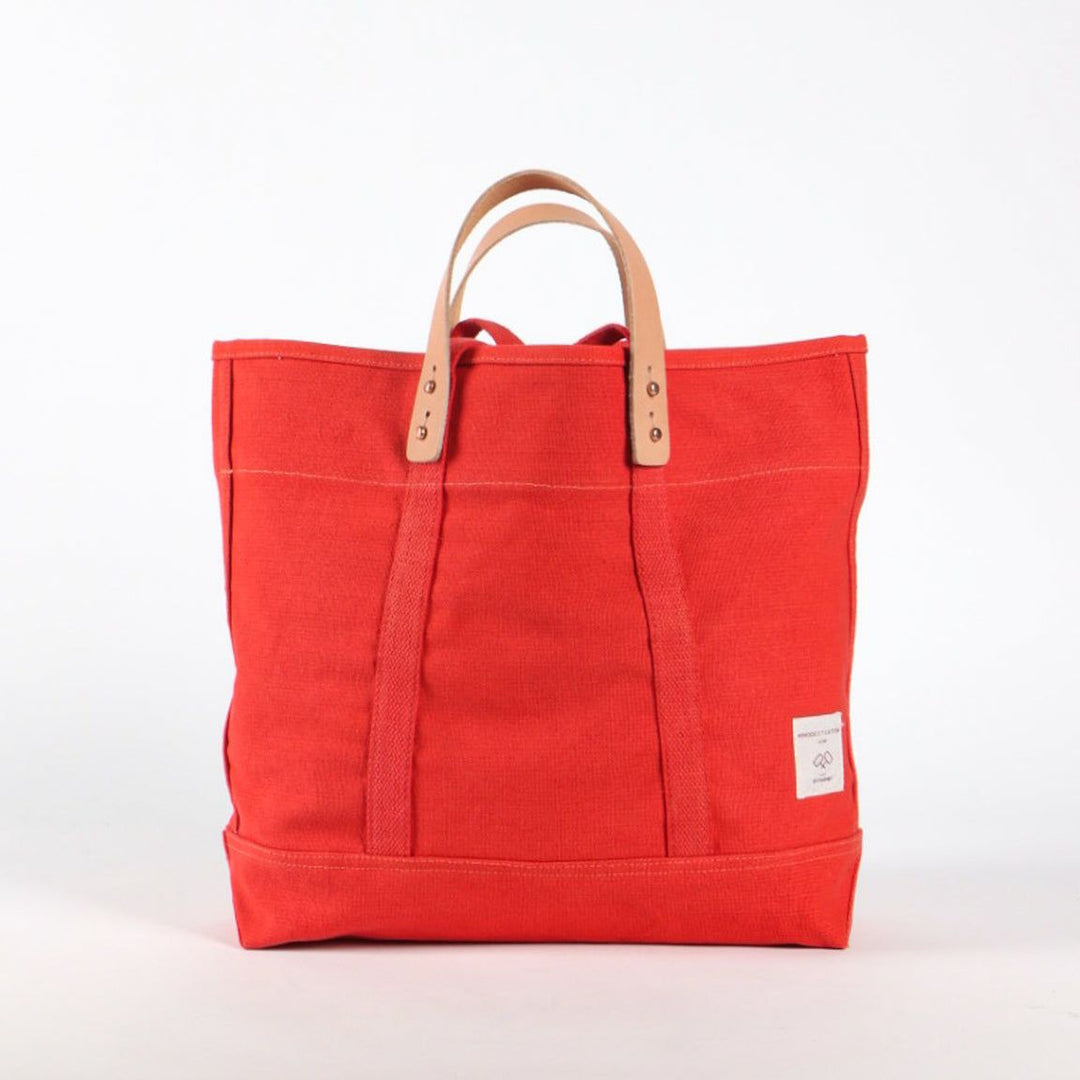 Red tote bag with brown handles on a white background