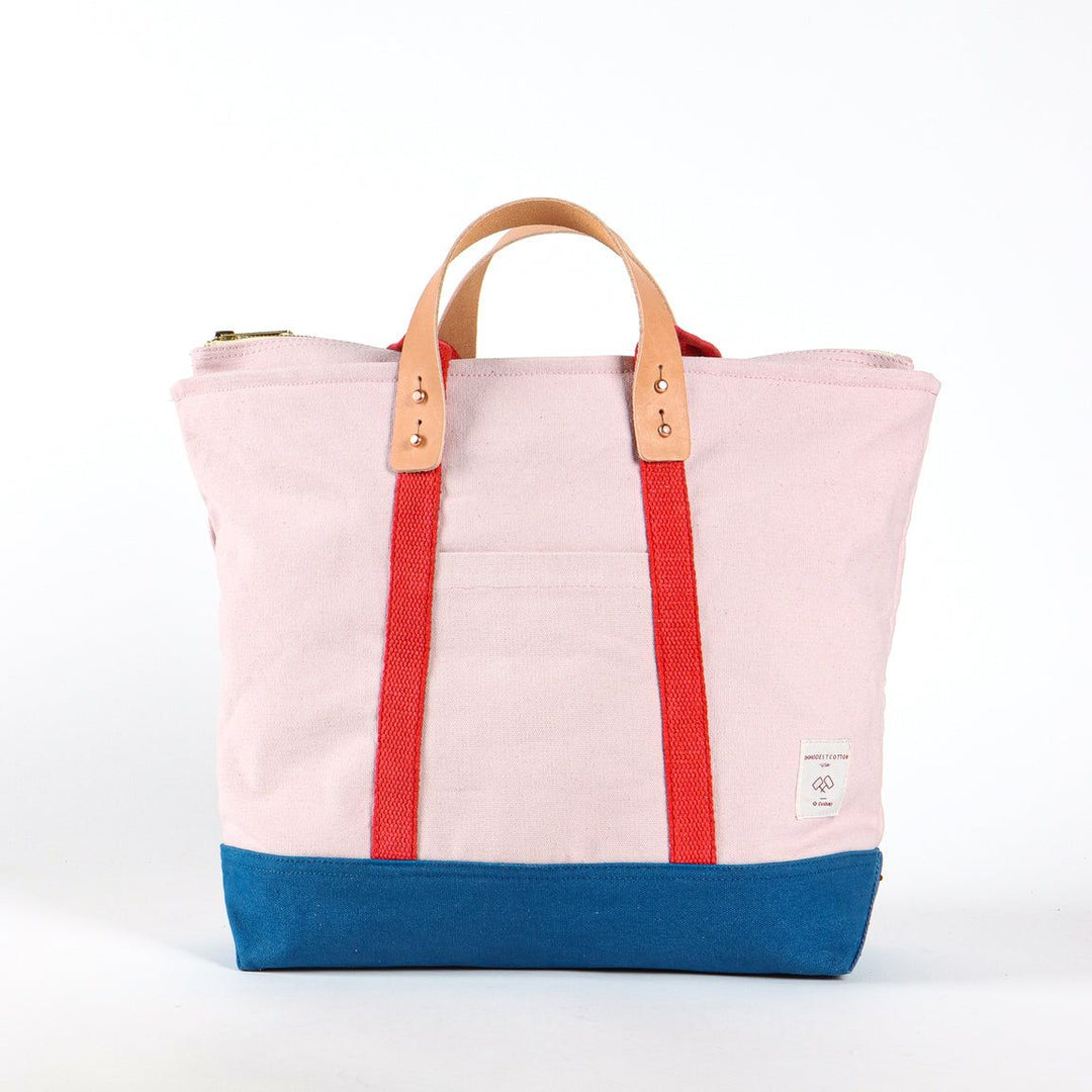Pink tote bag with red straps and blue base on a white background