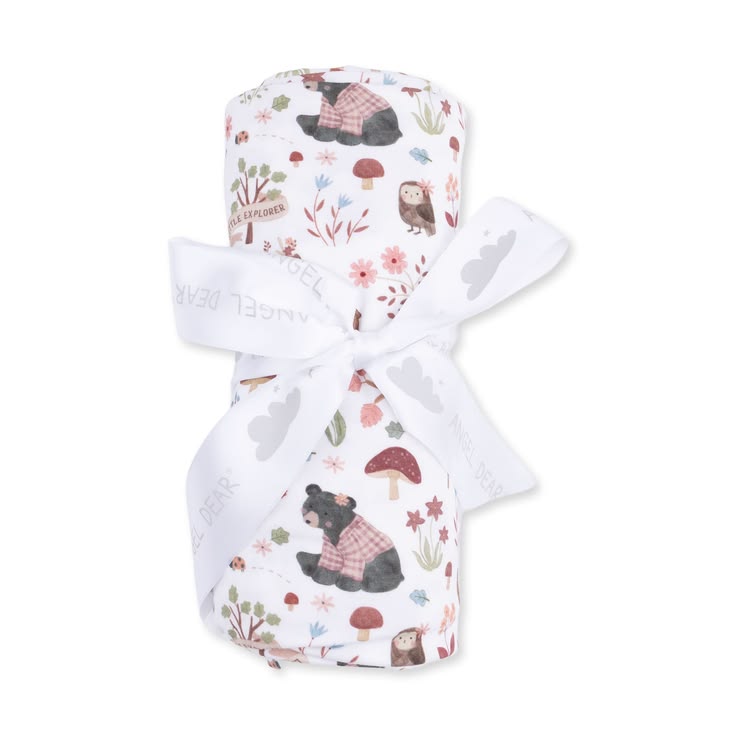 A rolled baby blanket or swaddle with a woodland bear print, tied with a white ribbon, on a plain white background.