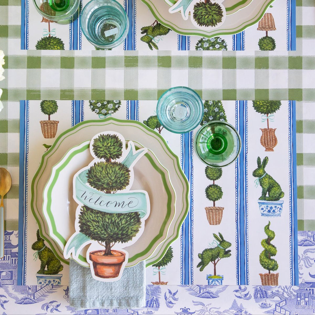 Decorative tablecloth with garden-themed design featuring plants and rabbits on a checkered background.