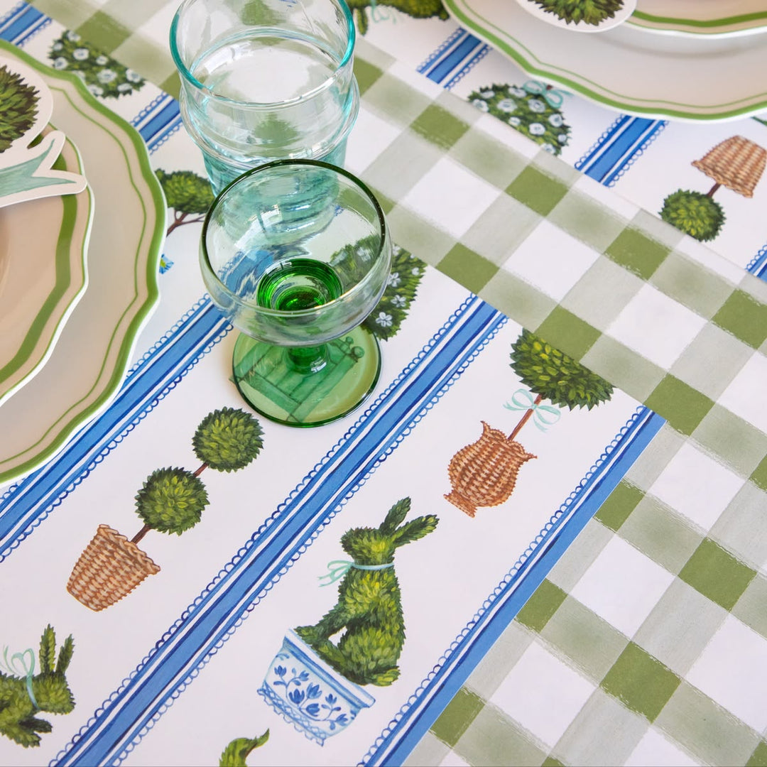 Table setting with a decorative tablecloth featuring plant patterns and glasses.