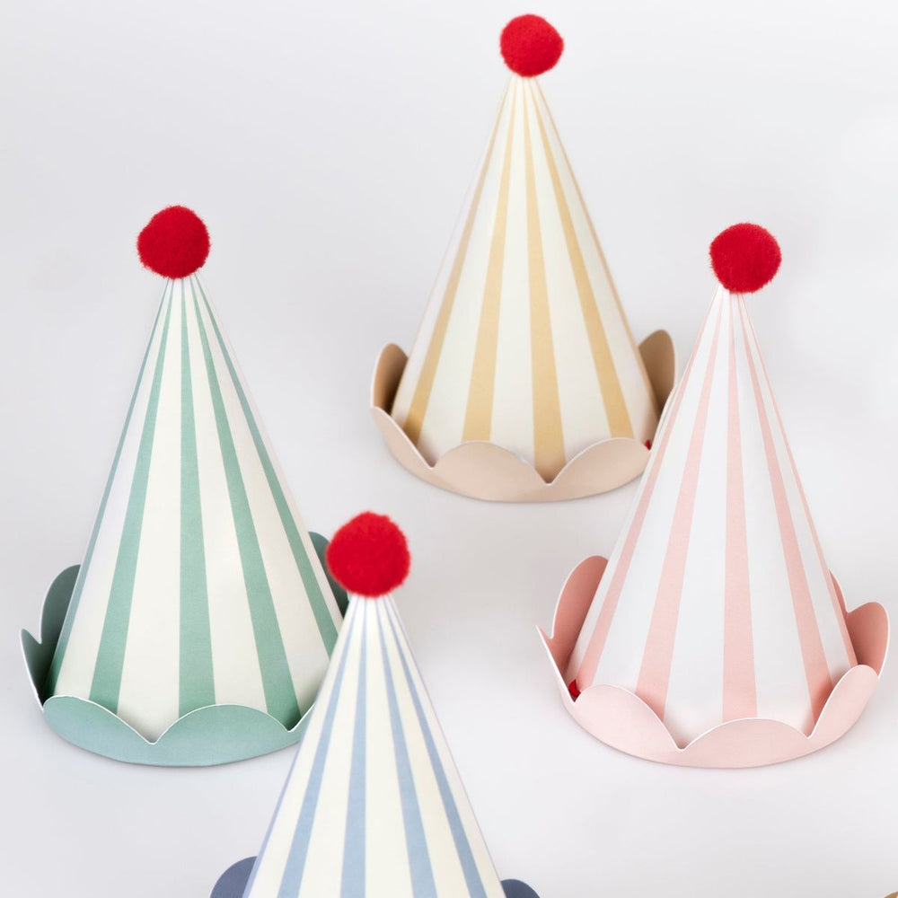 Set of colorful party hats with pom-poms on a light gray background